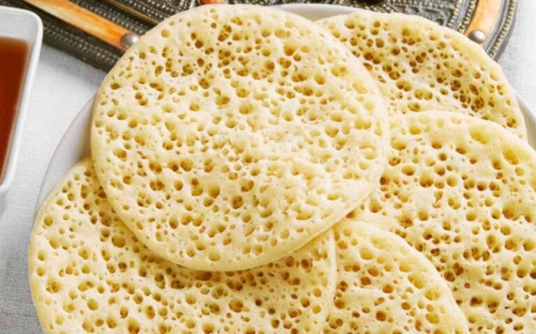 Assiette de Baghrirs (crêpes mille trous) traditionnelles marocaines servies avec du miel.