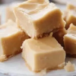 Carrés de sucre à la crème maison, crémeux et fondants, disposés sur une assiette avec un morceau manquant.