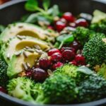 Salade de brocoli avec avocat, graines de tournesol et canneberges, vue de près dans un bol noir.